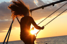 Woman on a swing with sunset in background