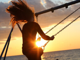 Woman on a swing with sunset in background