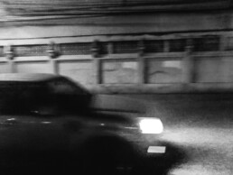 Grainy image of a car driving at night